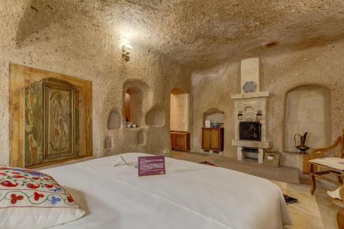a bedroom with a bed in a room with a fireplace at Taskonaklar in Uchisar
