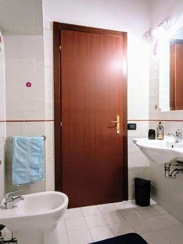 a bathroom with a sink and a wooden door at My home apartments in Pienza