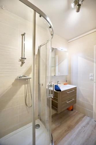 une salle de bain avec douche et lavabo dans l'établissement L'essentiel - parking - centre ville, à Concarneau
