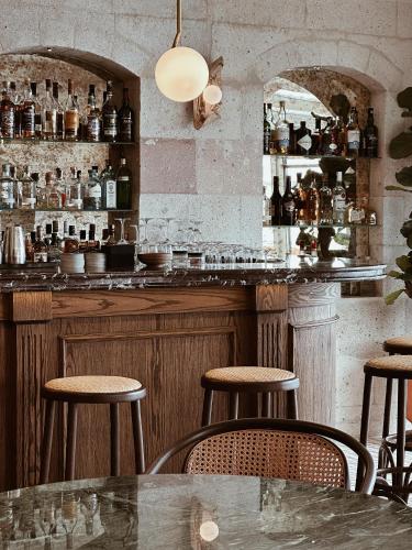 a bar with a table and stools in a room at Taskonaklar in Uchisar