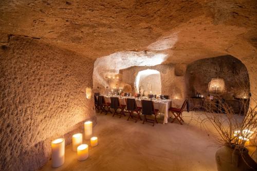 a room with a table and candles in a cave at Taskonaklar in Uchisar