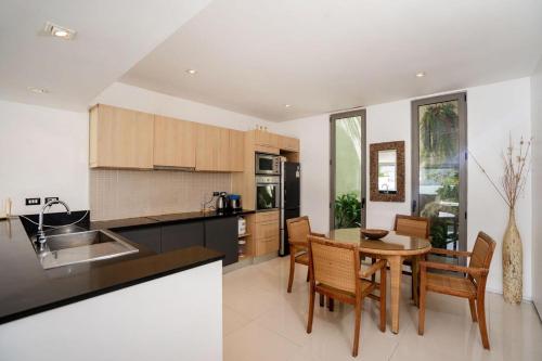 a kitchen and dining room with a table and chairs at Atika Villas xero oceanfront pool villa in Patong Beach