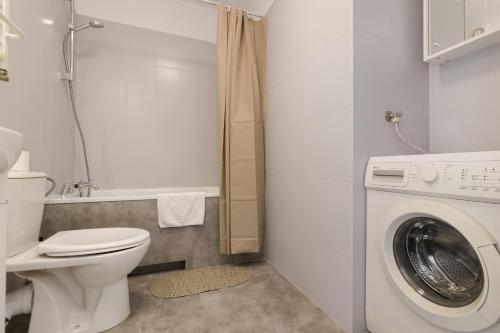 a bathroom with a toilet and a washing machine at ShortStayPoland Apartamentowa B180 in Warsaw
