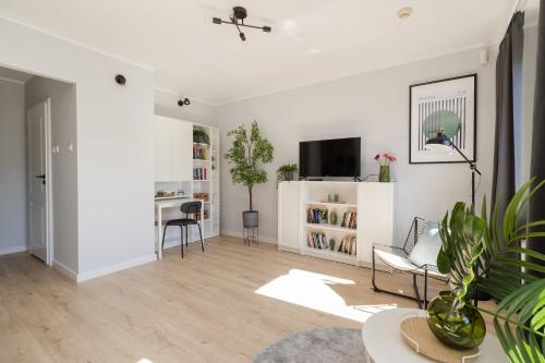 a living room with white walls and wooden floors at ShortStayPoland Apartamentowa B180 in Warsaw