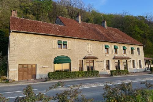 a large brick building with a brown roof at La chaumette in Pannessières