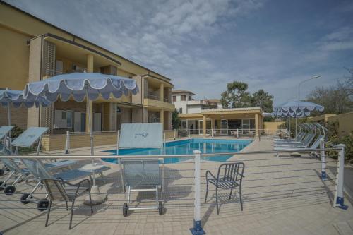 a resort with a pool and chairs and a building at Hotel Residence Il Conero 2 in Numana
