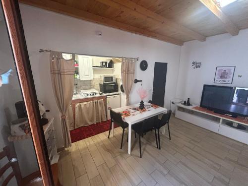 a living room with a table and a kitchen at MuSa Apartment in Catania