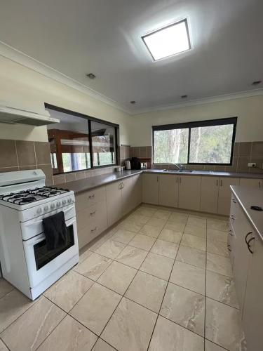 a kitchen with a stove and a white stove top oven at Farm Stay - 2 Bedroom cottage in Murphys Creek