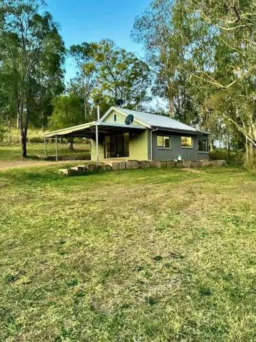 a house with a yard in front of it at Farm Stay - 2 Bedroom cottage in Murphys Creek