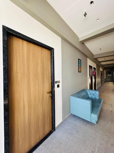 a large door in a hallway with a blue couch at Hotel Gold Palace Inn in Surat