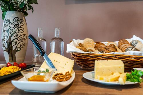 a table topped with cheese and a basket of bread at Hotel Formula Int. & Puravita SPA in Rosolina