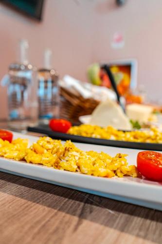 a plate of food on a table with tomatoes at Hotel Formula Int. & Puravita SPA in Rosolina