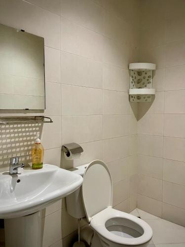 a bathroom with a sink and a toilet and a mirror at Comfort Apartment- Family only in Tangier