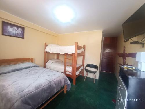 a bedroom with a bunk bed and a chair at La Finca Tarma in Tarma