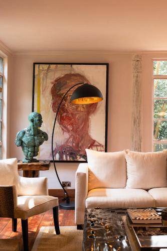 a living room with a couch and a painting at Hemingways Eden Residence in Nairobi