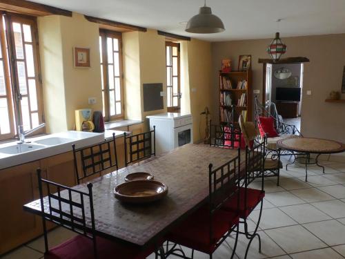 a kitchen and dining room with a table and chairs at Gîte Ô Pois Papillon in Saint-Sornin