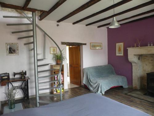 a room with a staircase and a bed and a fireplace at Gîte Ô Pois Papillon in Saint-Sornin