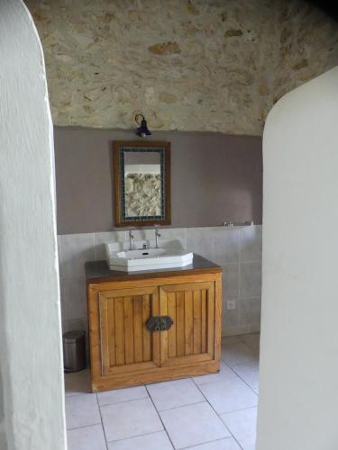 a bathroom with a sink and a mirror at Gîte Ô Pois Papillon in Saint-Sornin
