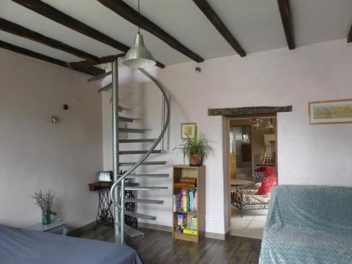 a bedroom with a spiral staircase in a room at Gîte Ô Pois Papillon in Saint-Sornin
