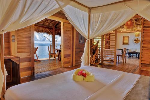 a bedroom with a bed with a bowl of fruit on it at Manja Kely Lodge in Nosy Be
