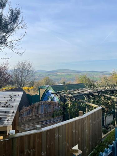 a garden with a greenhouse and a fence at Glamping in the 2nd Field in Aughrim