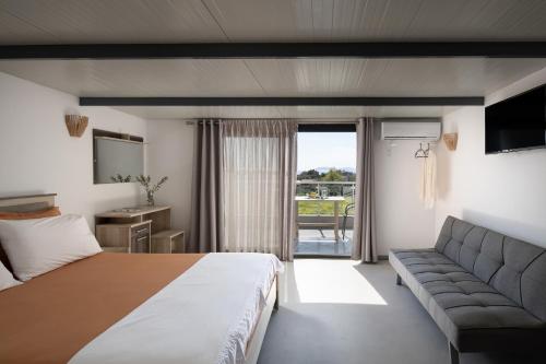 une chambre d'hôtel avec un lit et un canapé dans l'établissement Villa Miranda Roshi, à Toroni