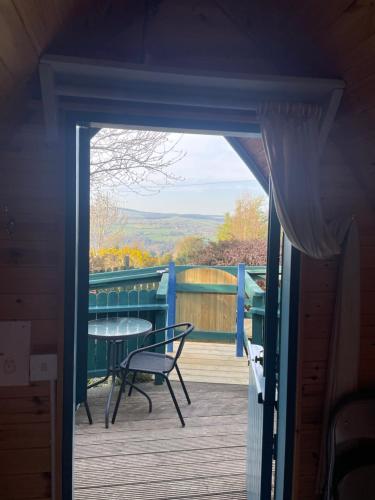 a door leading to a deck with a table and chair at Glamping in the 2nd Field in Aughrim