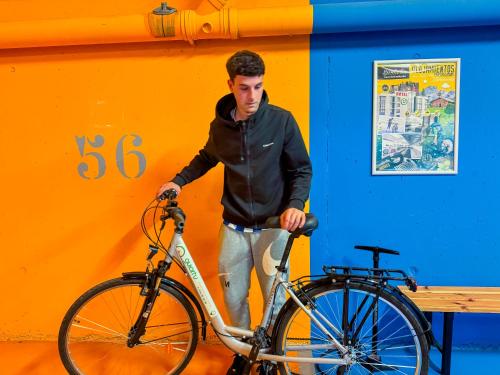 a man is standing next to a bike at Hotel Jardines de Uleta Suites in Vitoria-Gasteiz