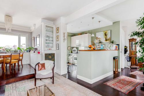 une cuisine et un salon avec une table et des chaises dans l'établissement Le Boursault - Stunning Penthouse, Terrace, Parking, à Paris