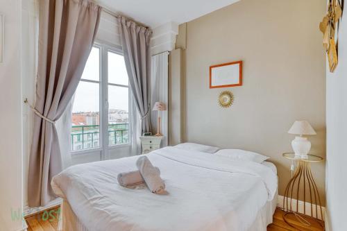 une chambre avec un lit blanc avec une fenêtre dans l'établissement Le Boursault - Stunning Penthouse, Terrace, Parking, à Paris
