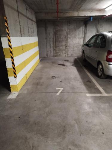 a parking garage with a car parked in it at Stan na dan Apartman Harmonija in Zalužani