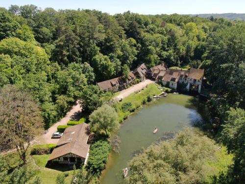 - une vue aérienne sur une maison et un lac dans l'établissement Le Moulin d'Andé, à Andé