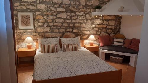 a bedroom with a bed and two lamps and a couch at Stone House Mia in Premantura