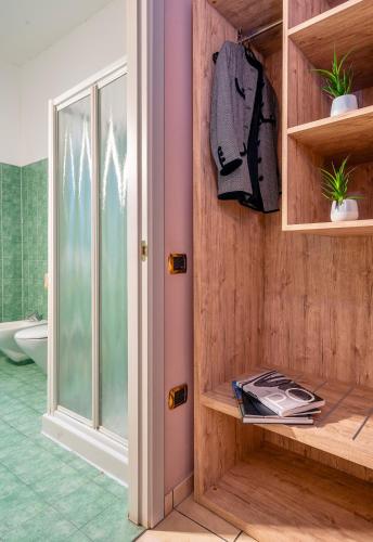 a bathroom with wooden walls and a glass door at Hotel Formula Int. & Puravita SPA in Rosolina