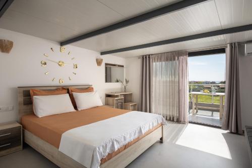 a bedroom with a bed and a clock on the wall at Villa Miranda Roshi in Toroni