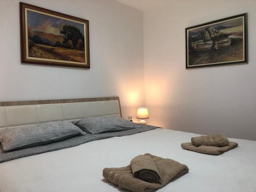 a bedroom with a bed with two towels on it at The Sloth - vacation home in Simići