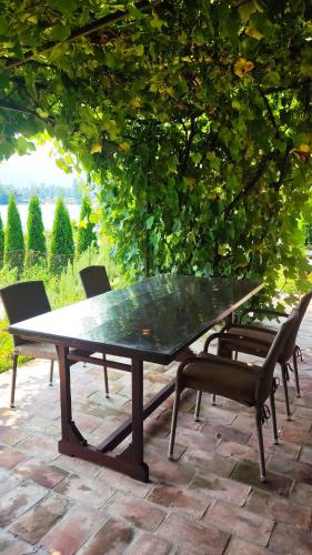 a ping pong table and chairs under a tree at The Sloth - vacation home in Simići