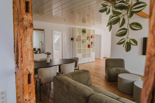 a living room with a couch and a table and chairs at Penthouse in Hildesheims Philosophen Viertel in Hildesheim