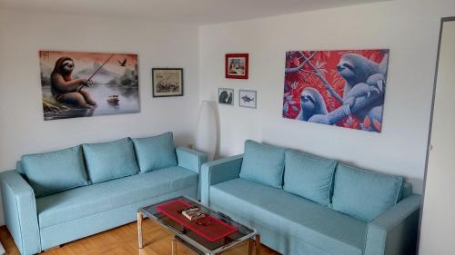 a living room with two blue couches and a table at The Sloth - vacation home in Simići