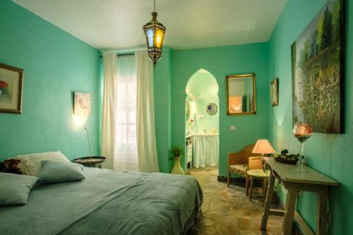 una camera da letto con pareti verdi, un letto e una scrivania di Casa Petra a Canillas de Aceituno