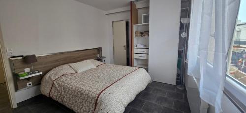 une petite chambre avec un lit et une fenêtre dans l'établissement Nid de vacances à Valras - Clim et proche plage, à Valras-Plage