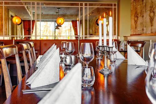 a long wooden table with wine glasses and candles at Original Sokos Hotel Puijonsarvi in Kuopio