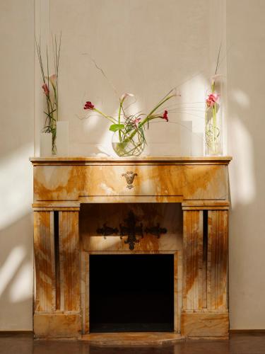 a fireplace with two flowers on top of it at Grand Hotel in Łódź