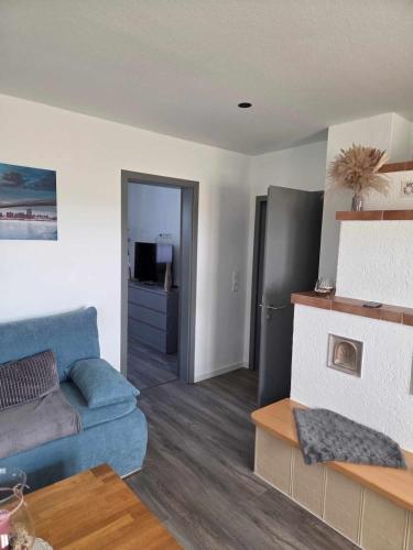 a living room with a blue couch and a kitchen at Ferienhaus Berg in Birstein