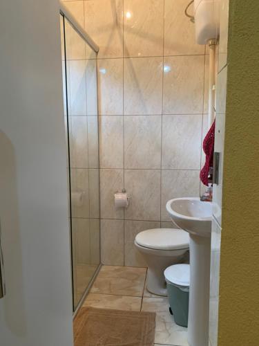 a bathroom with a shower and a toilet and a sink at Estância dos Lagos in Cláudio