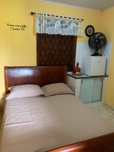 a bed with a wooden headboard in a bedroom at Estância dos Lagos in Cláudio