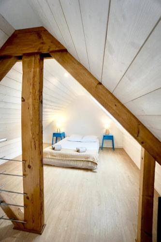 - une chambre mansardée avec un lit et 2 tables bleues dans l'établissement Le Duplex - centre ville, à Concarneau