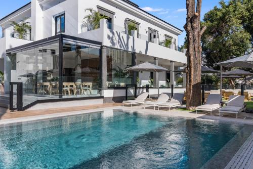 a swimming pool in front of a building at Las Dunas de Santa Catalina Boutique House in Las Palmas de Gran Canaria