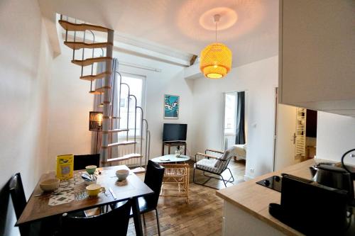 Il dispose d'une cuisine et d'un salon avec une table et un escalier en colimaçon. dans l'établissement Le Duplex - centre ville, à Concarneau