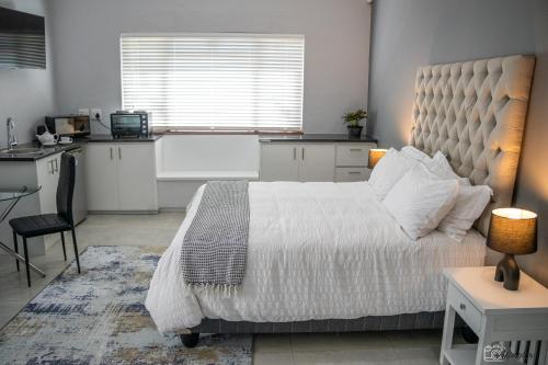 Un dormitorio con una cama grande y una cocina. en NamaStay, en Ciudad del Cabo